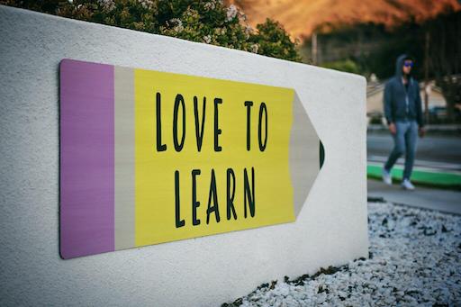 "Love to learn" written on a board like pencil pointing to a direction.