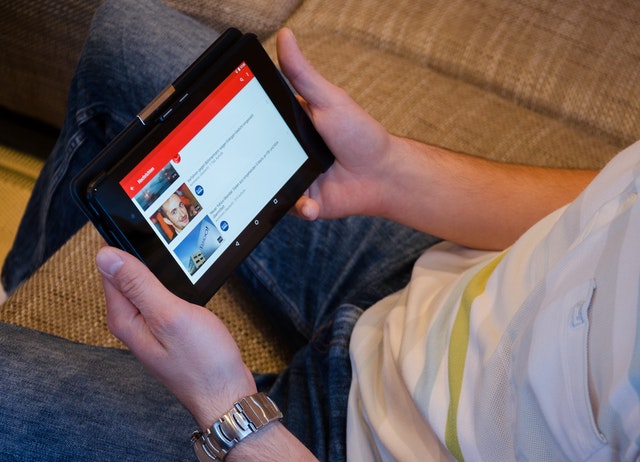 A guy is watching YouTube on a tablet
